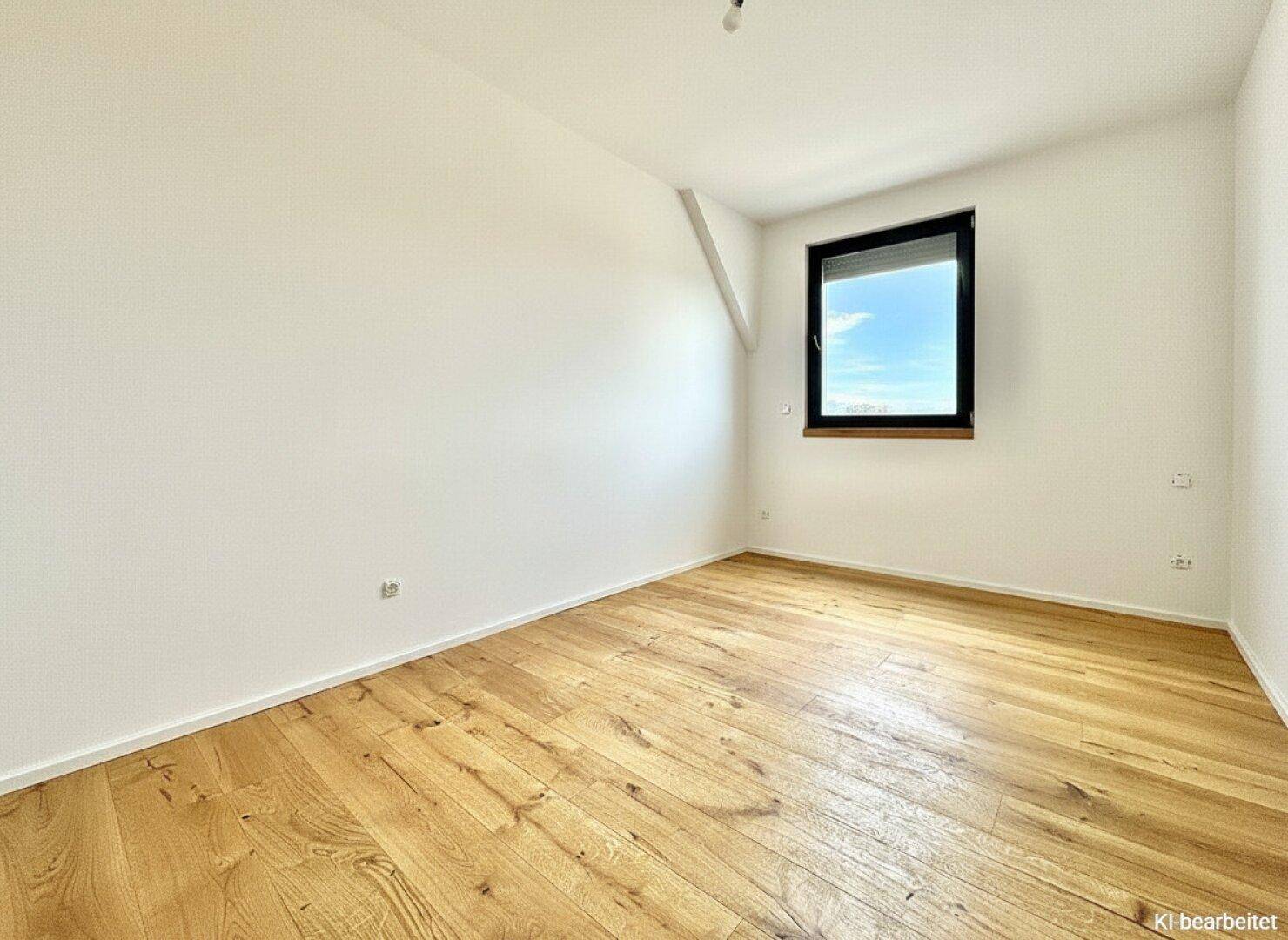 Helles Schlafzimmer mit Holzboden und einem Fenster, das viel Tageslicht bietet.