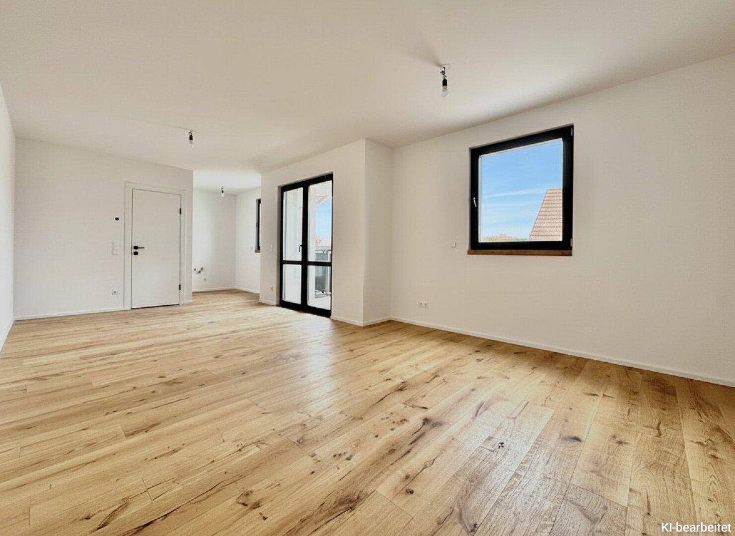 Lichtdurchfluteter Wohnbereich mit hellem Holzboden und Zugang zu einem Balkon oder einer Terrasse.