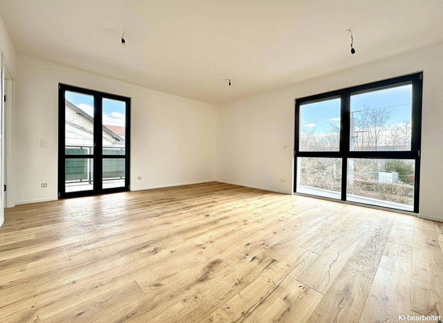 Geräumiger, heller Raum mit Holzboden und großen Fenstern, die einen weiten Blick bieten.