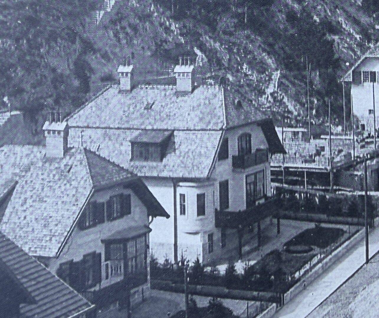 Historische Schwarz-Weiß-Aufnahme von zwei Villen mit gepflegten Gärten und traditioneller Architektur.