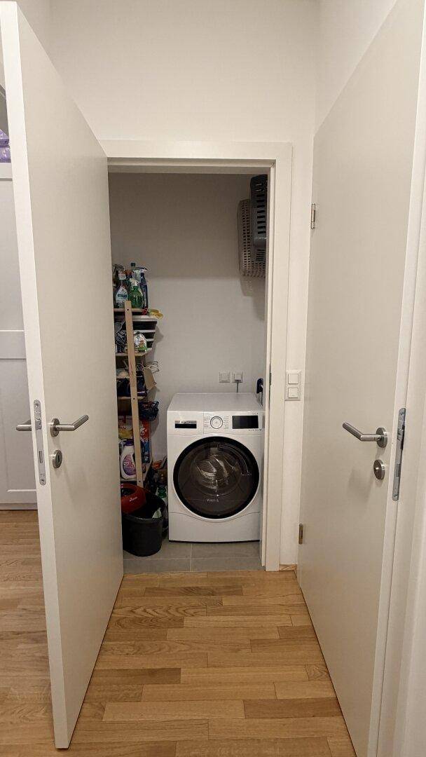 Praktischer Hauswirtschaftsraum mit Waschmaschine und Regalen für Vorräte.