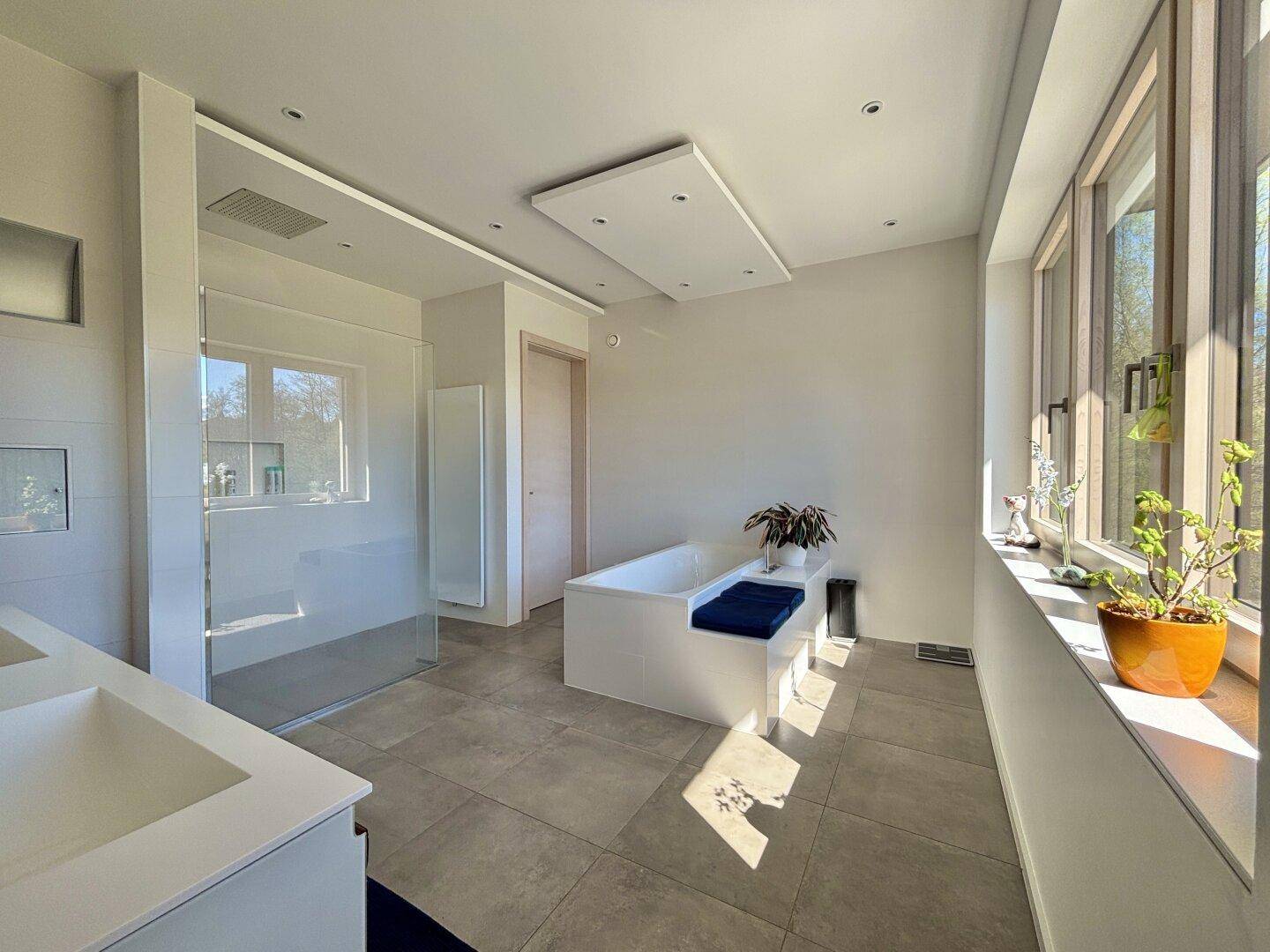 Geräumiges, modernes Badezimmer mit großer Dusche, Doppelwaschtisch und viel Tageslicht.