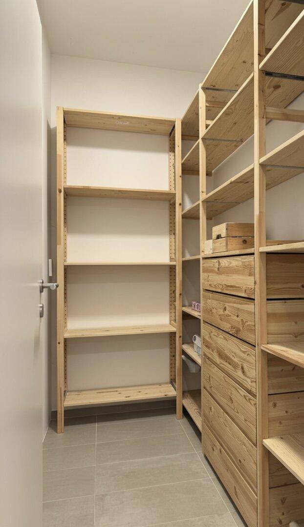 Geräumiger Abstellraum mit offenen Holzregalen und Schubladen für vielseitige Aufbewahrung.