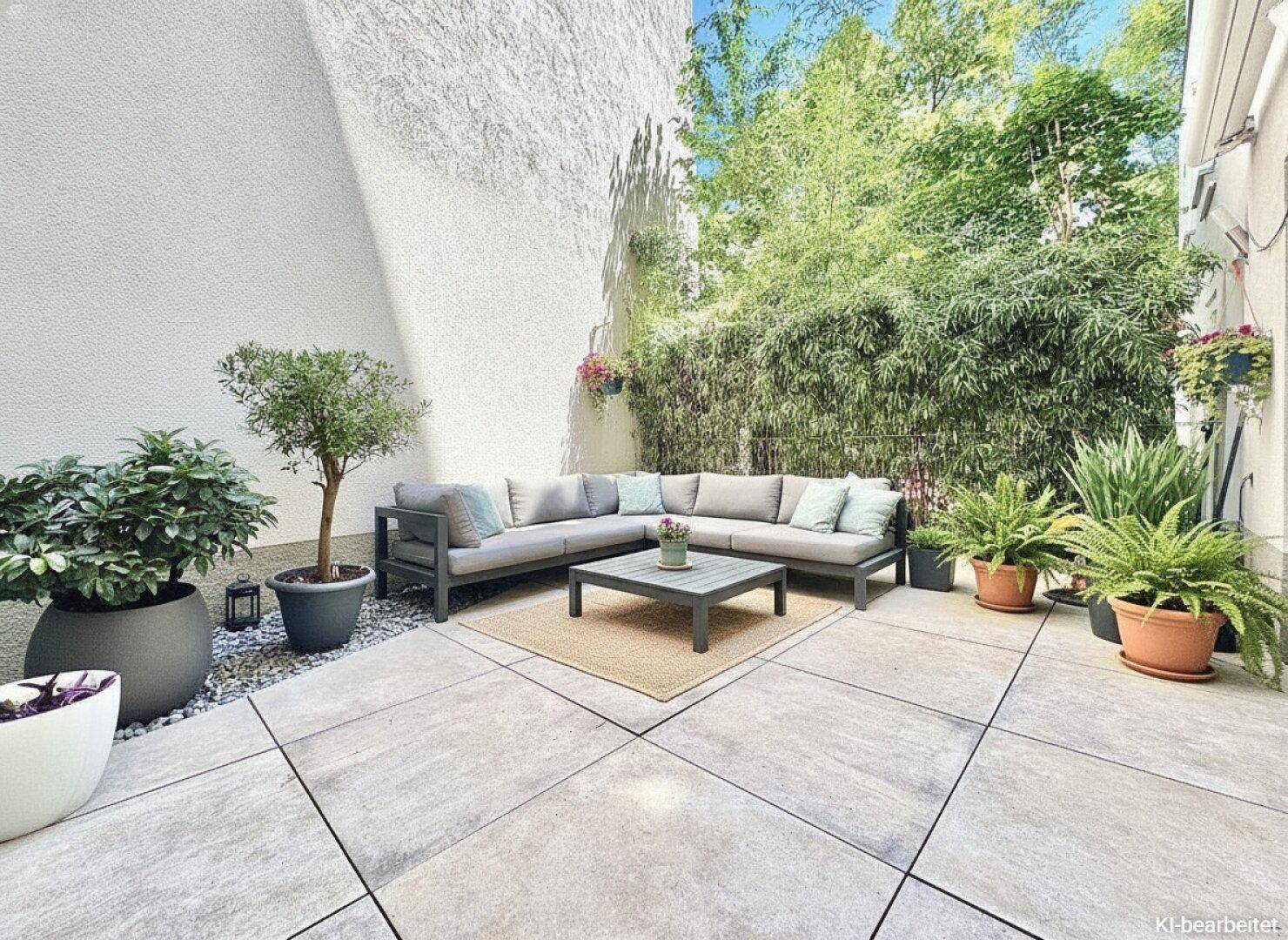 Moderne Terrasse mit bequemen Outdoor-Möbeln, grünen Pflanzen und einer Bambushecke für Privatsphäre.