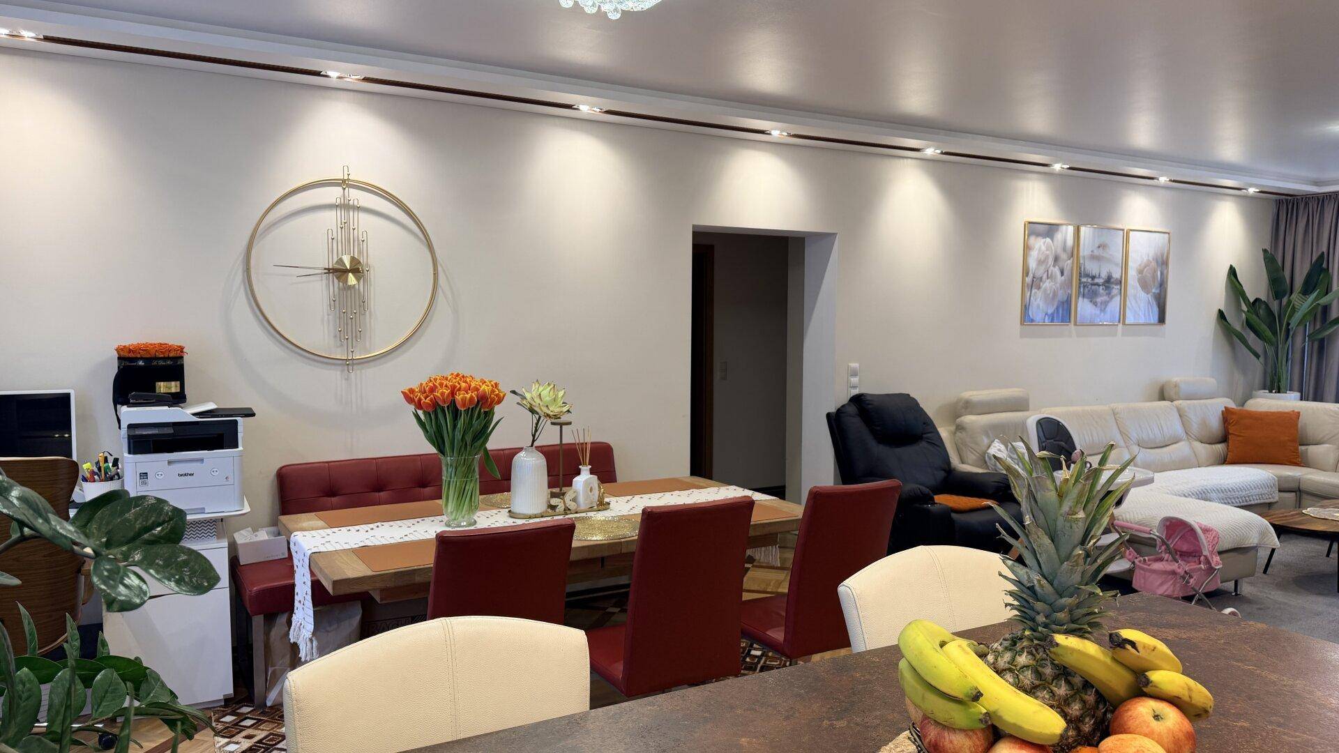 Geräumiger Wohn- und Essbereich mit modernem Esstisch, bequemen Stühlen und einem Sofa im Hintergrund.