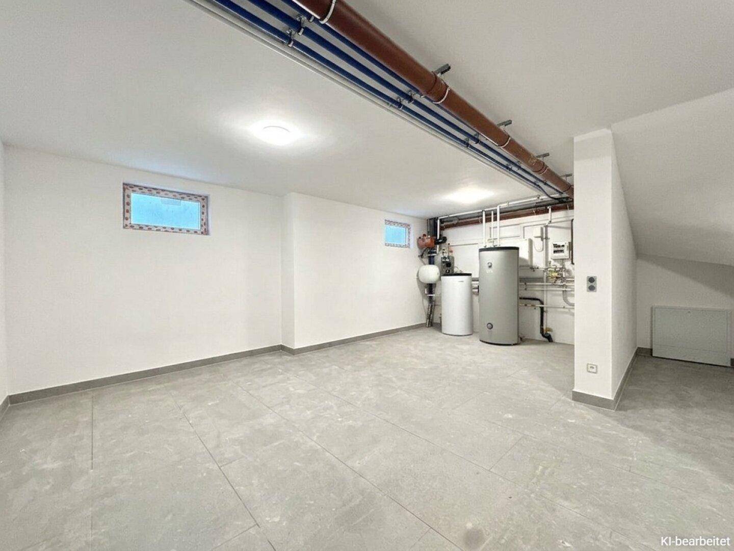 Funktionaler Hauswirtschaftsraum im Keller mit Heizungsanlage, Warmwasserspeicher und Fliesenboden.