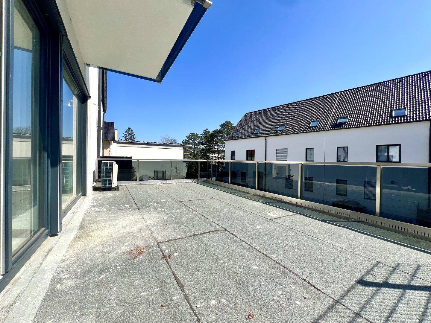 Weitläufige Terrasse mit Blick auf die umliegenden Gebäude und den blauen Himmel.