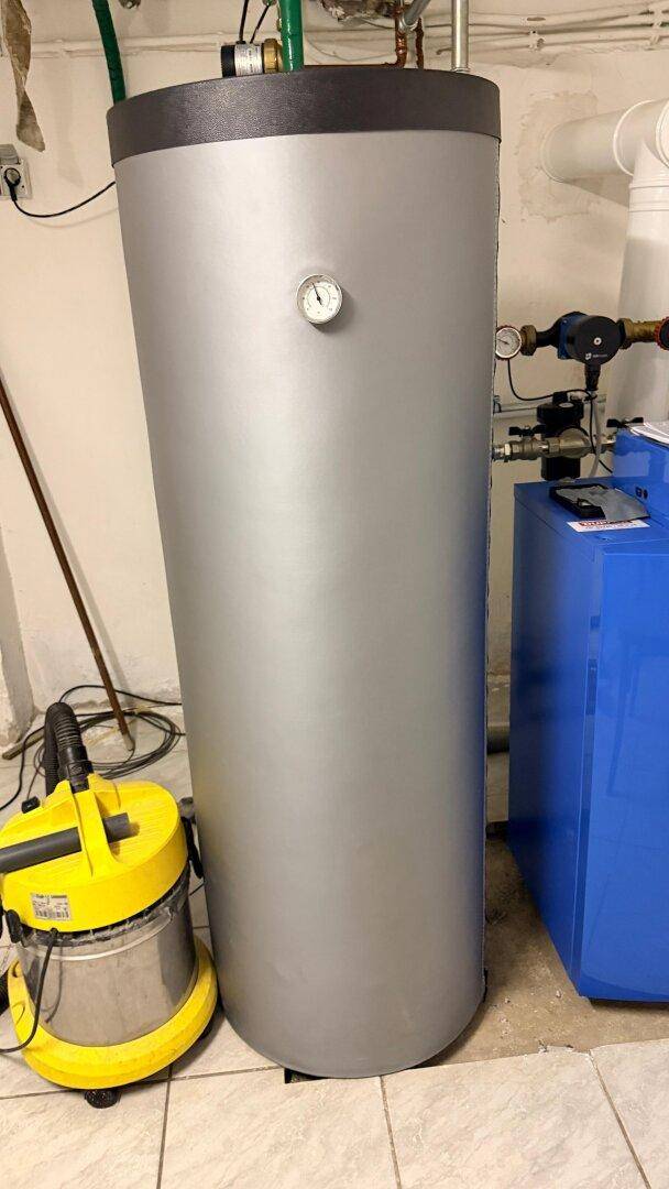 Großer Warmwasserspeicher und Heizungsanlage in einem Hauswirtschaftsraum.
