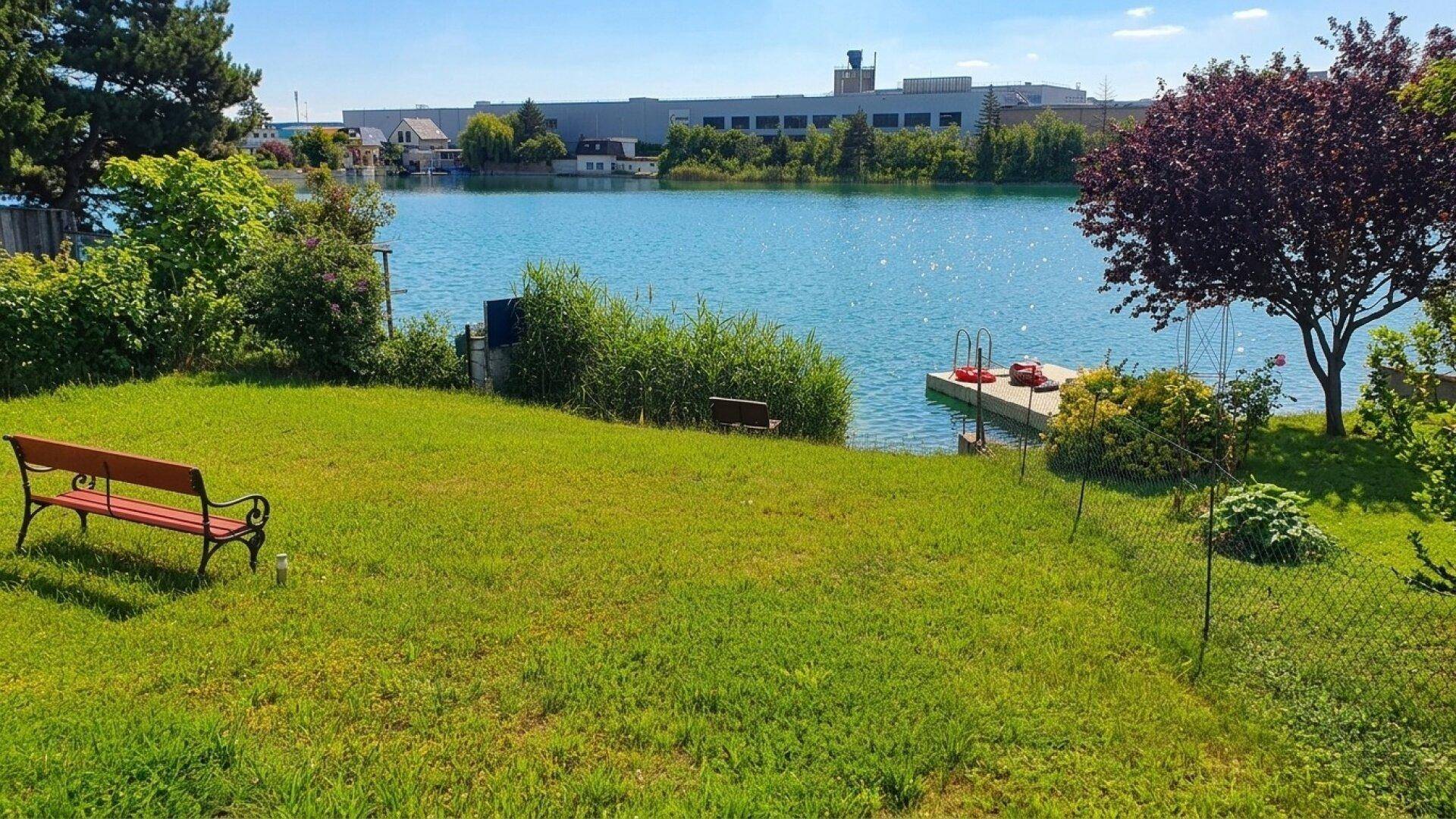 Grüner Gartenbereich mit Sitzbank und direktem Zugang zum See, umgeben von Natur.