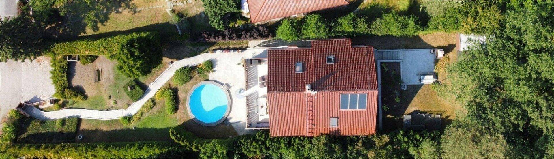 Luftaufnahme eines Hauses mit Garten, Pool und gepflegter Außenanlage.