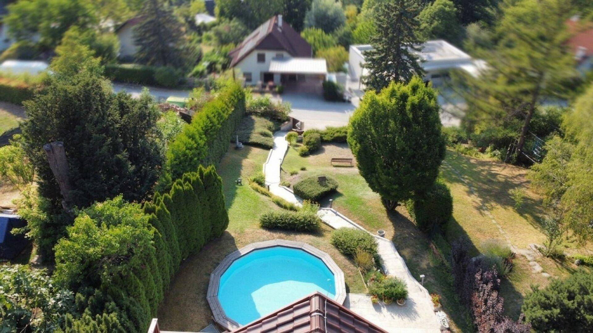 Weitläufiges Grundstück mit Pool, Gartenanlage und Blick auf das Hauptgebäude.