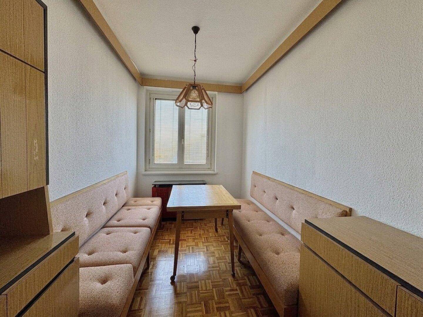 Gemütlicher Essbereich mit Holztisch, Sitzbänken und Parkettboden.
