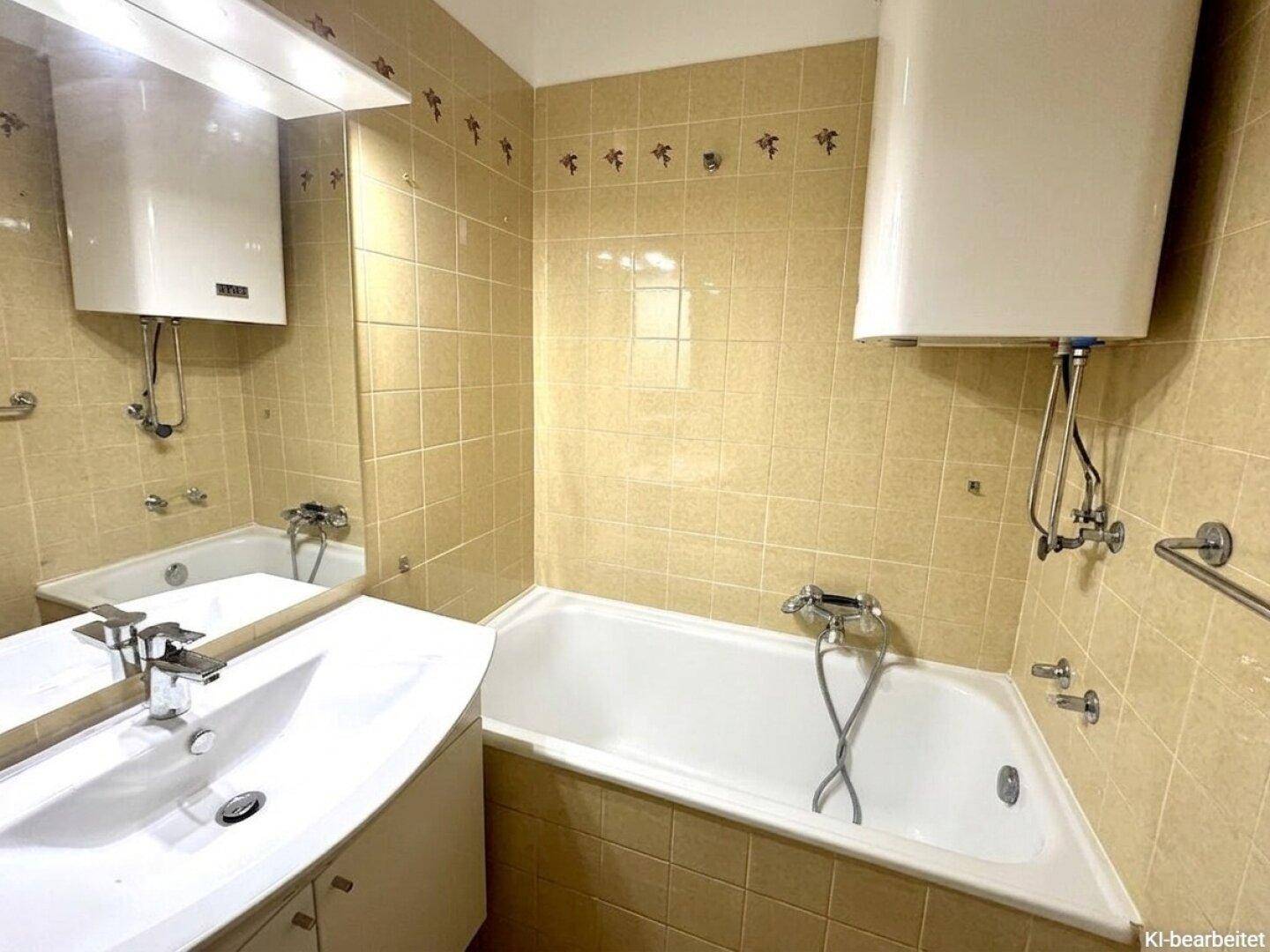 Badezimmer mit beigefarbenen Fliesen, Badewanne und Waschbecken.