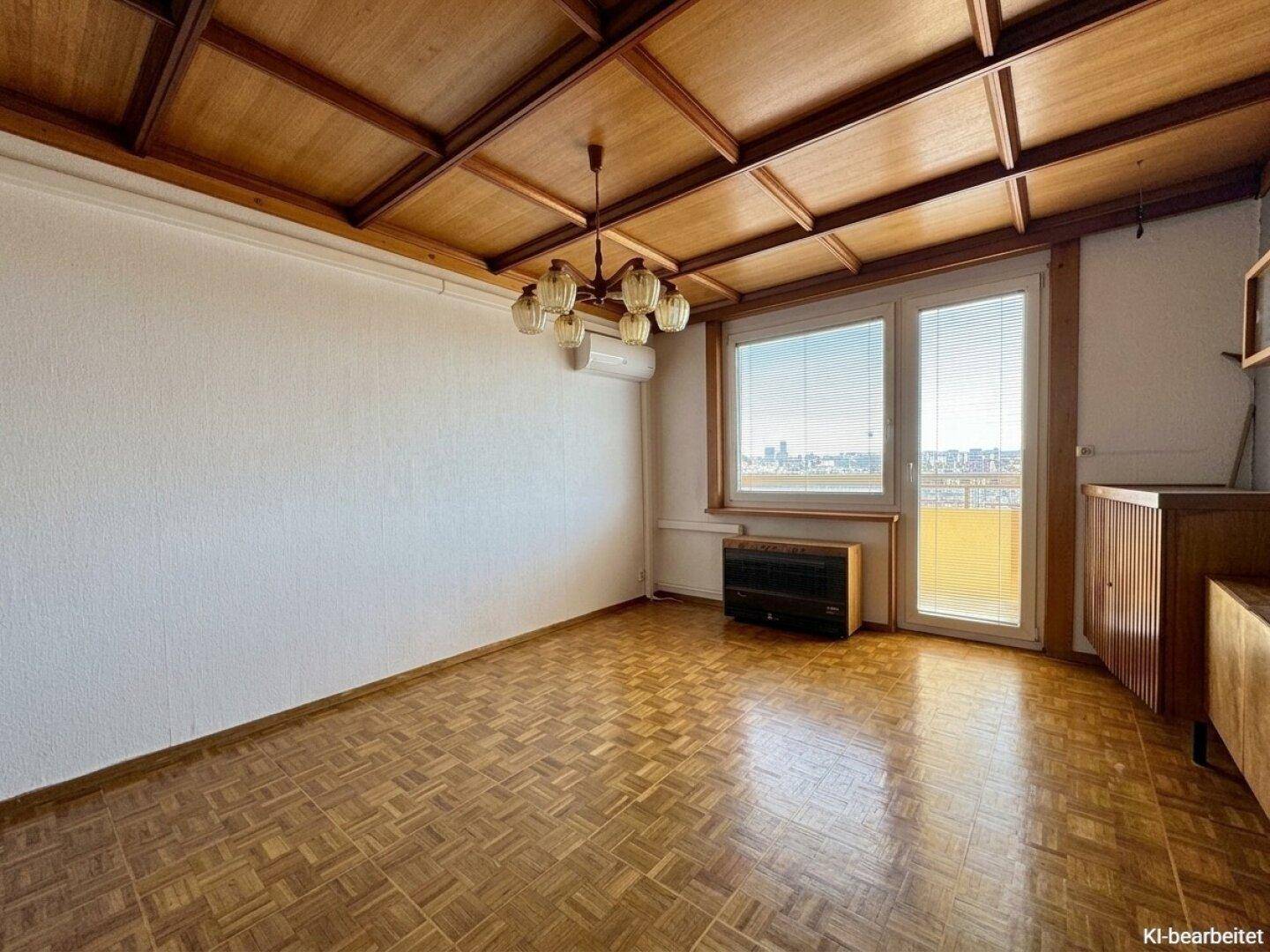 Wohnzimmer mit Holzkassettendecke, Parkettboden und Blick auf die Stadt.