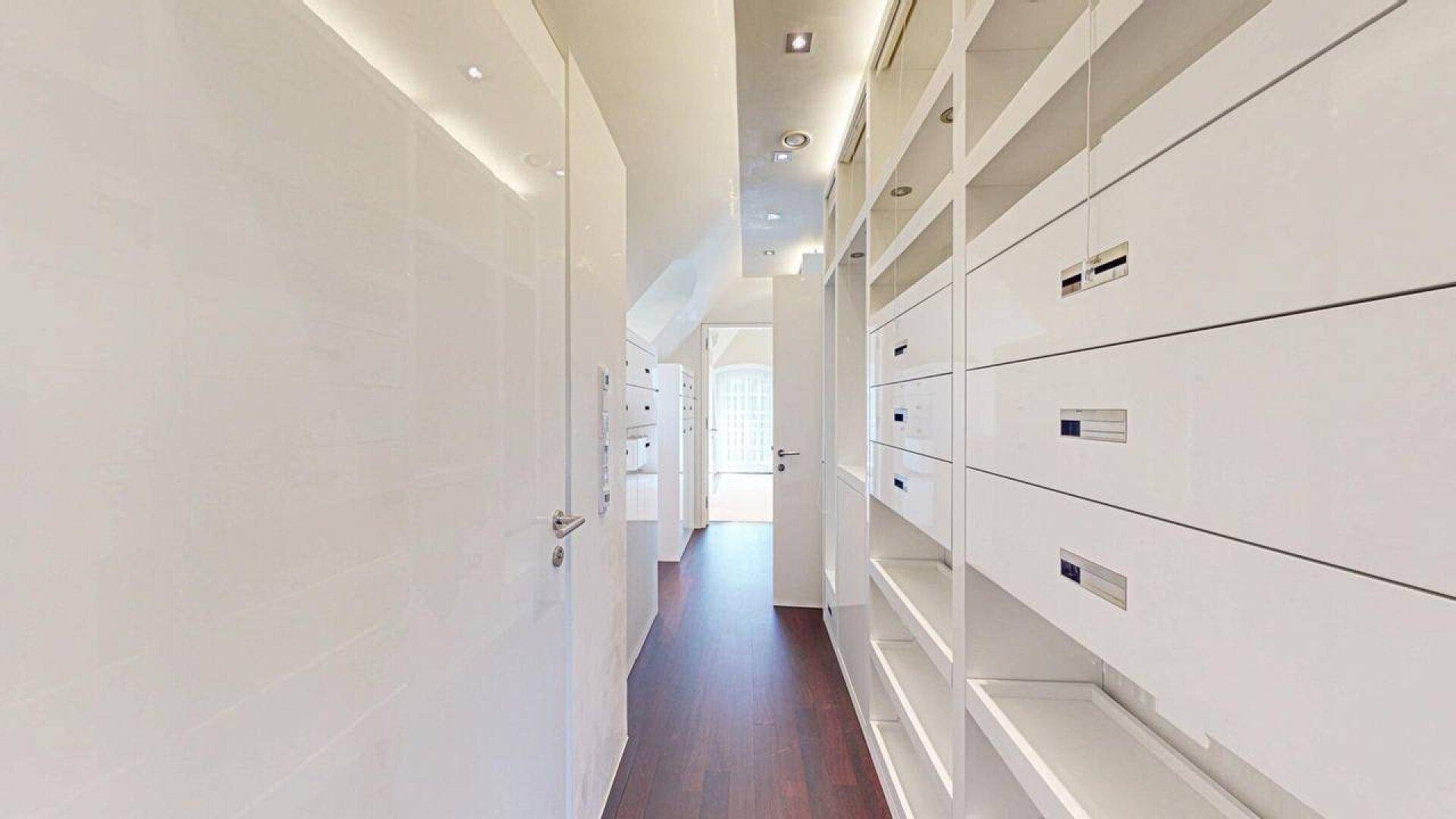 Geräumiger begehbarer Kleiderschrank mit vielen Fächern und Schubladen.