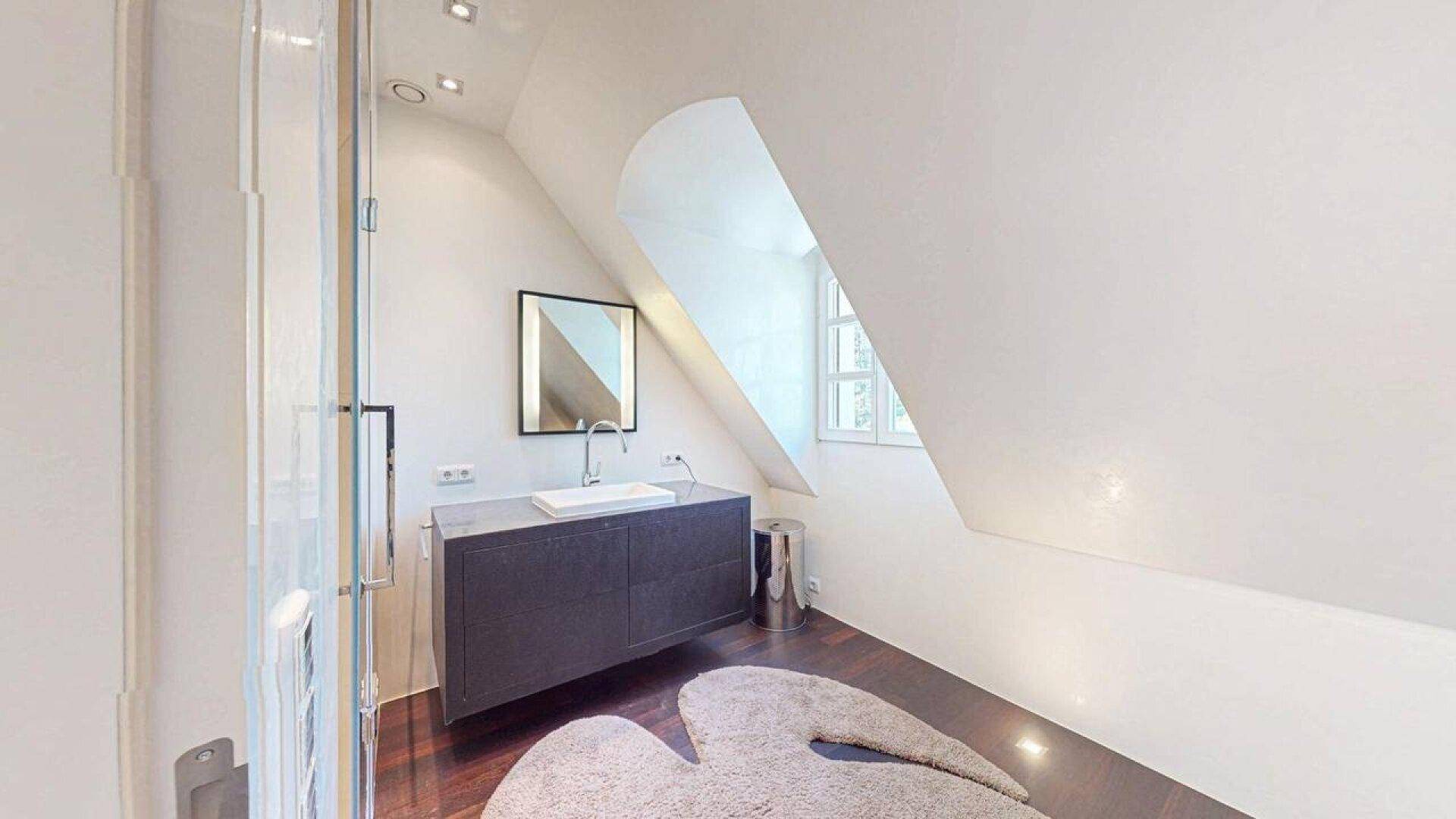 Modernes Badezimmer im Dachgeschoss mit Waschtisch, Dusche und Dachschräge.