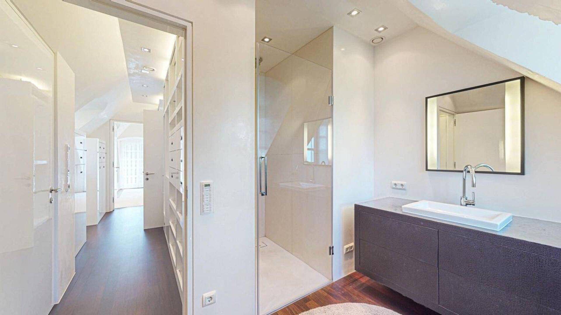 Modernes Badezimmer mit Dusche und direktem Zugang zum begehbaren Kleiderschrank.