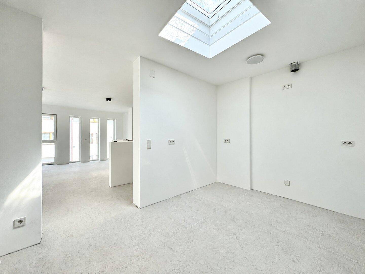 Lichtdurchfluteter Flur mit Oberlicht und hohen Decken in einem Neubau.