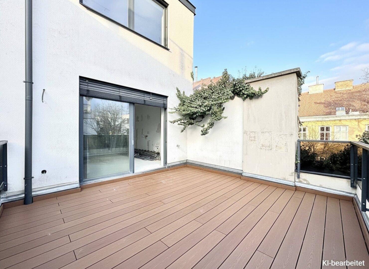 Geräumige Terrasse mit Holzdielenboden und Zugang zu einem Innenraum, der renoviert wird.