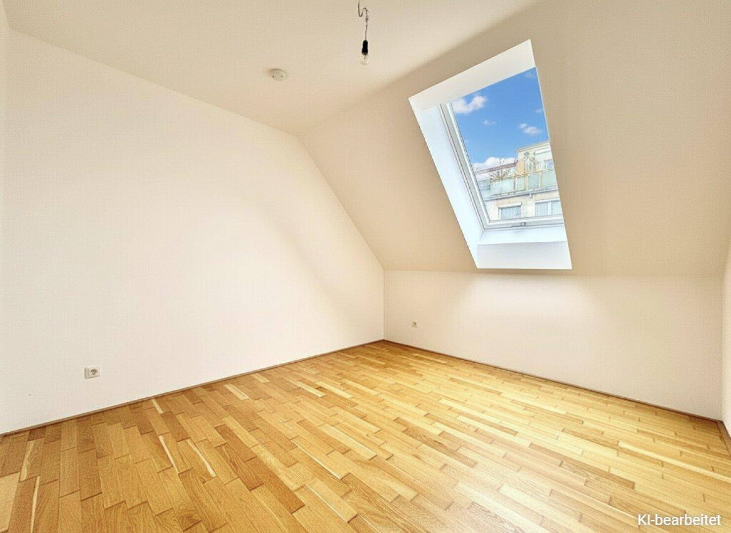 Gemütliches Zimmer im Dachgeschoss mit Parkettboden, schrägen Wänden und einem großen Dachfenster.