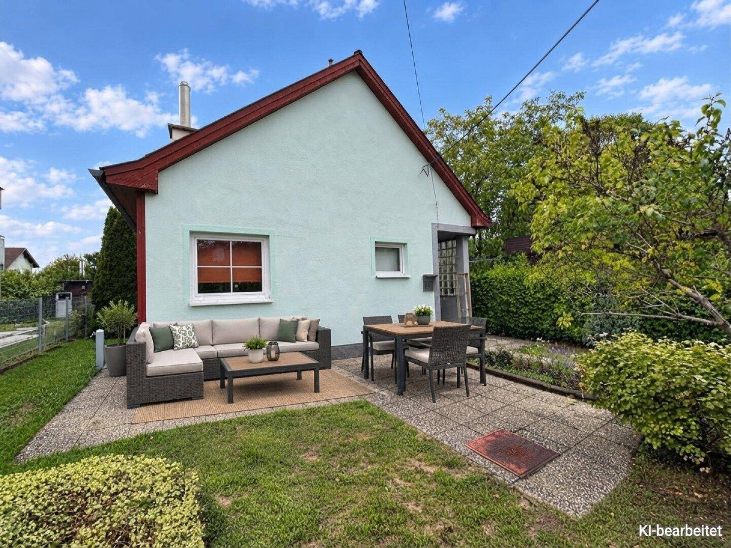 Gemütliche Terrasse mit modernen Gartenmöbeln und Essbereich, umgeben von Grün.