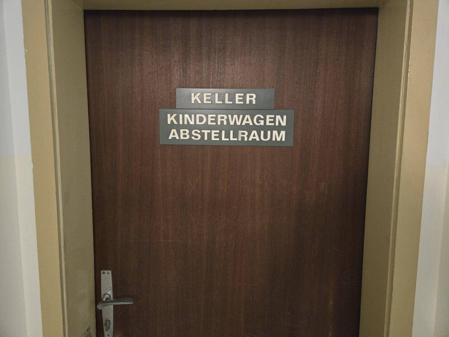 Tür zu den Gemeinschaftsräumen, gekennzeichnet als Keller und Kinderwagen Abstellraum.