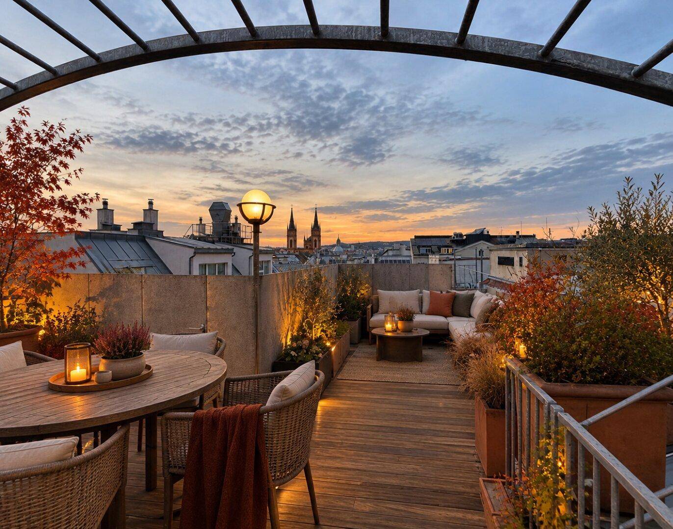 Große Dachterrasse mit gemütlichen Sitzbereichen, Pflanzen und weitem Stadtblick bei Sonnenuntergang.