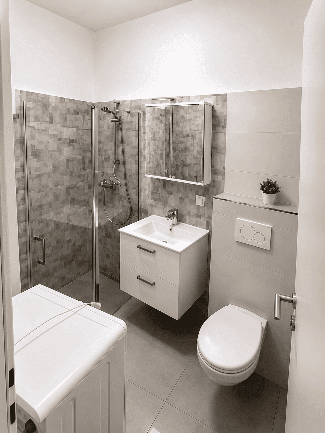 Modernes Badezimmer mit Duschkabine, Hänge-WC und Waschbeckenunterschrank.