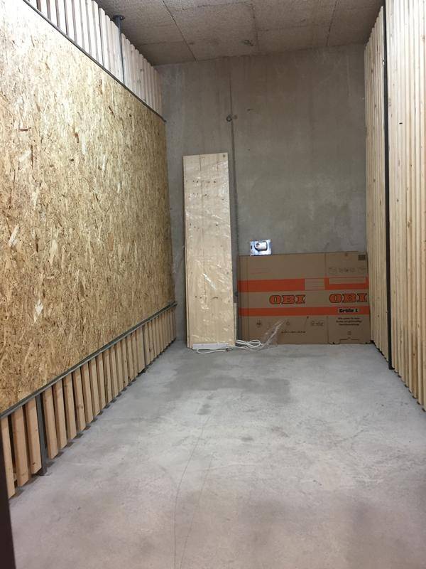 Unfertiger Lagerraum oder Keller mit Betonwänden und teilweise verkleidet mit Holzplatten.