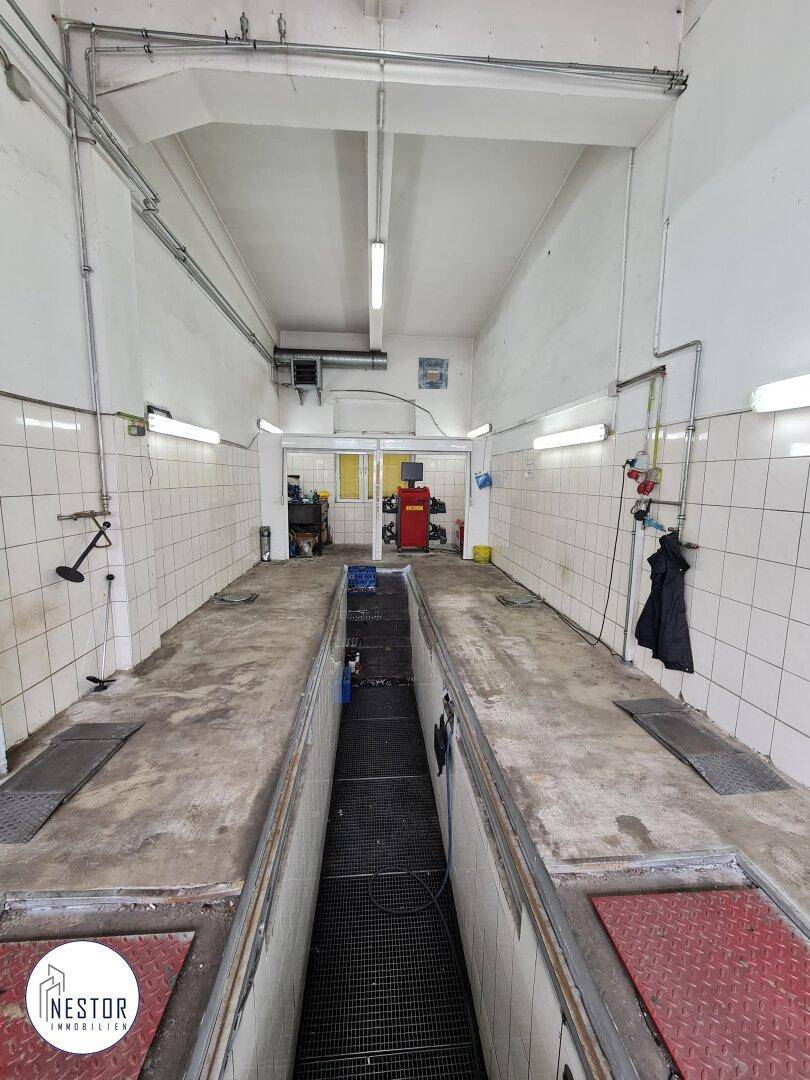 Weitere Innenansicht des Servicegrubenbereichs, die die Länge der Grube mit gefliesten Wänden zeigt.