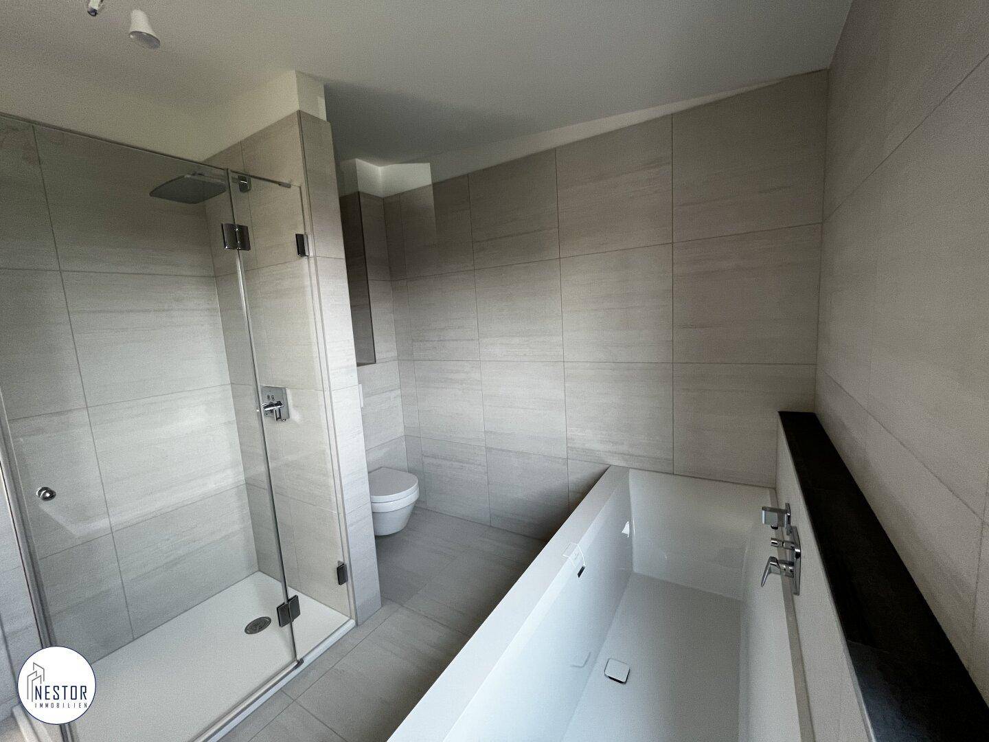 Modernes Badezimmer mit begehbarer Dusche, Badewanne und Wand-WC in zeitgemäßem Design.