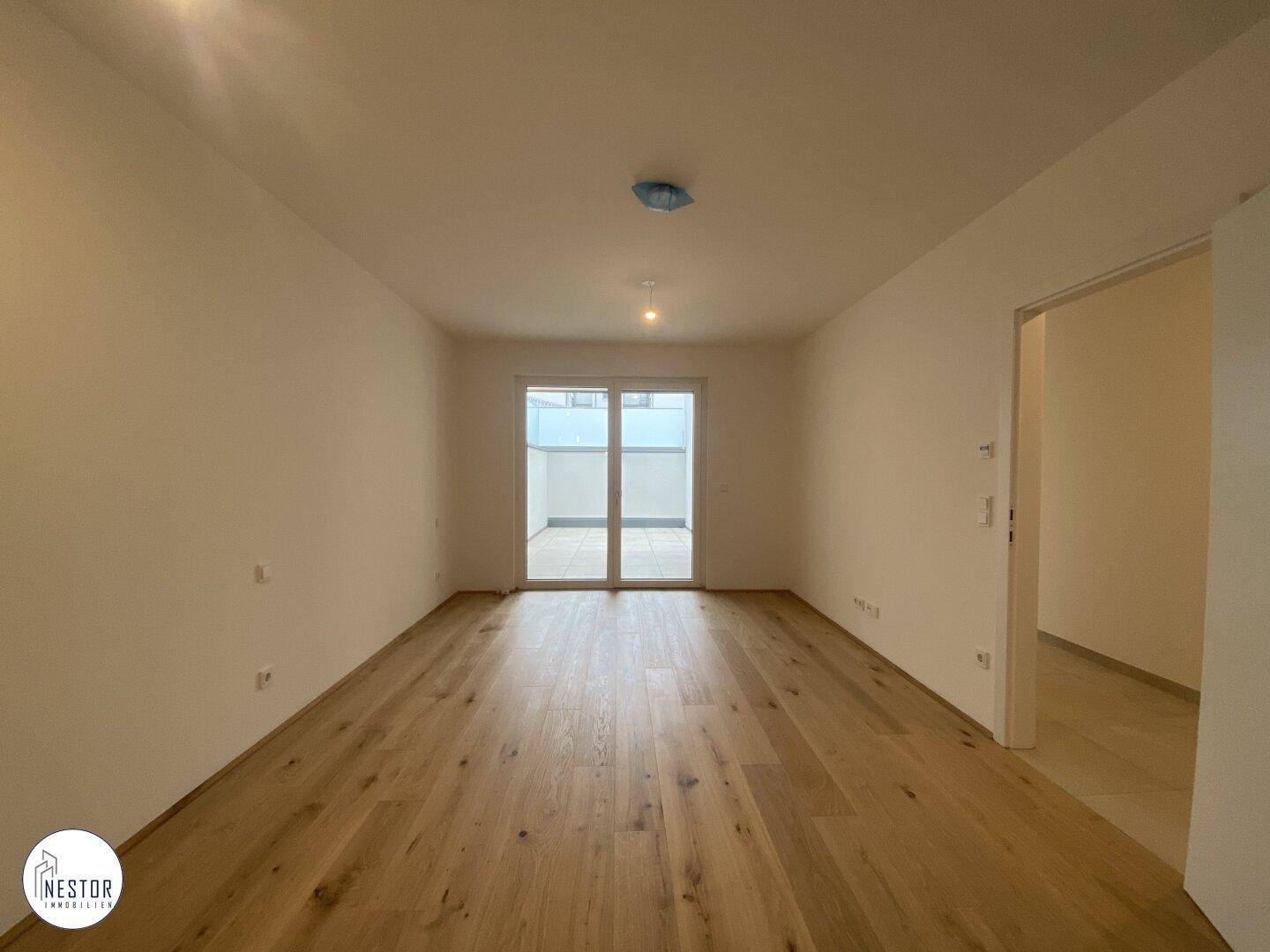 Geräumiges Schlafzimmer mit Holzboden und direktem Zugang zu einem privaten Außenbereich.