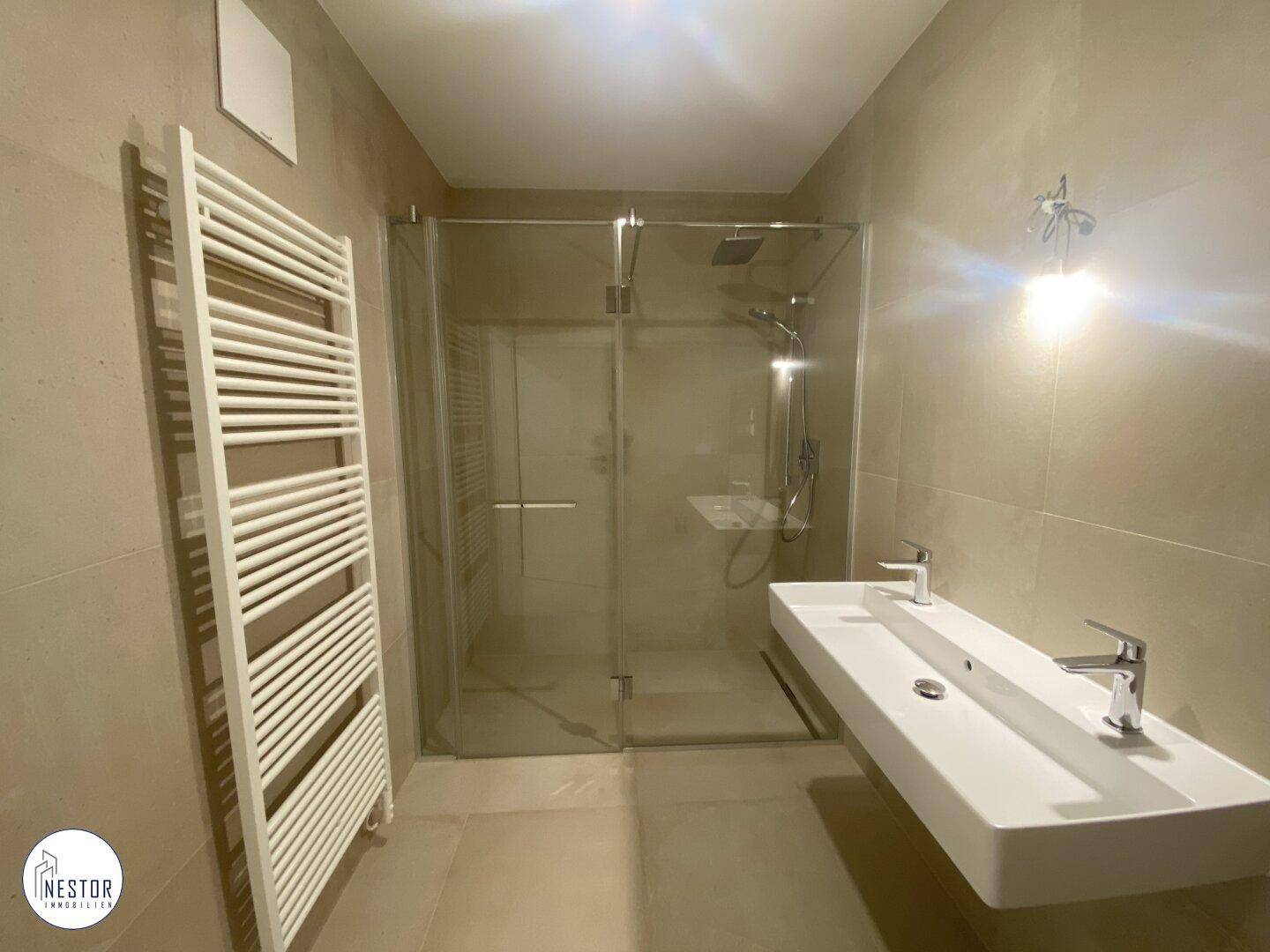 Modernes Badezimmer mit großer begehbarer Dusche, Doppelwaschbecken und Handtuchheizkörper.