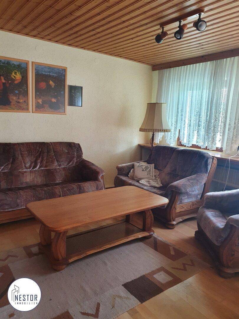 Wohnzimmer mit Holzdecke, bequemen Sofas, Couchtisch und Blick auf den Garten.
