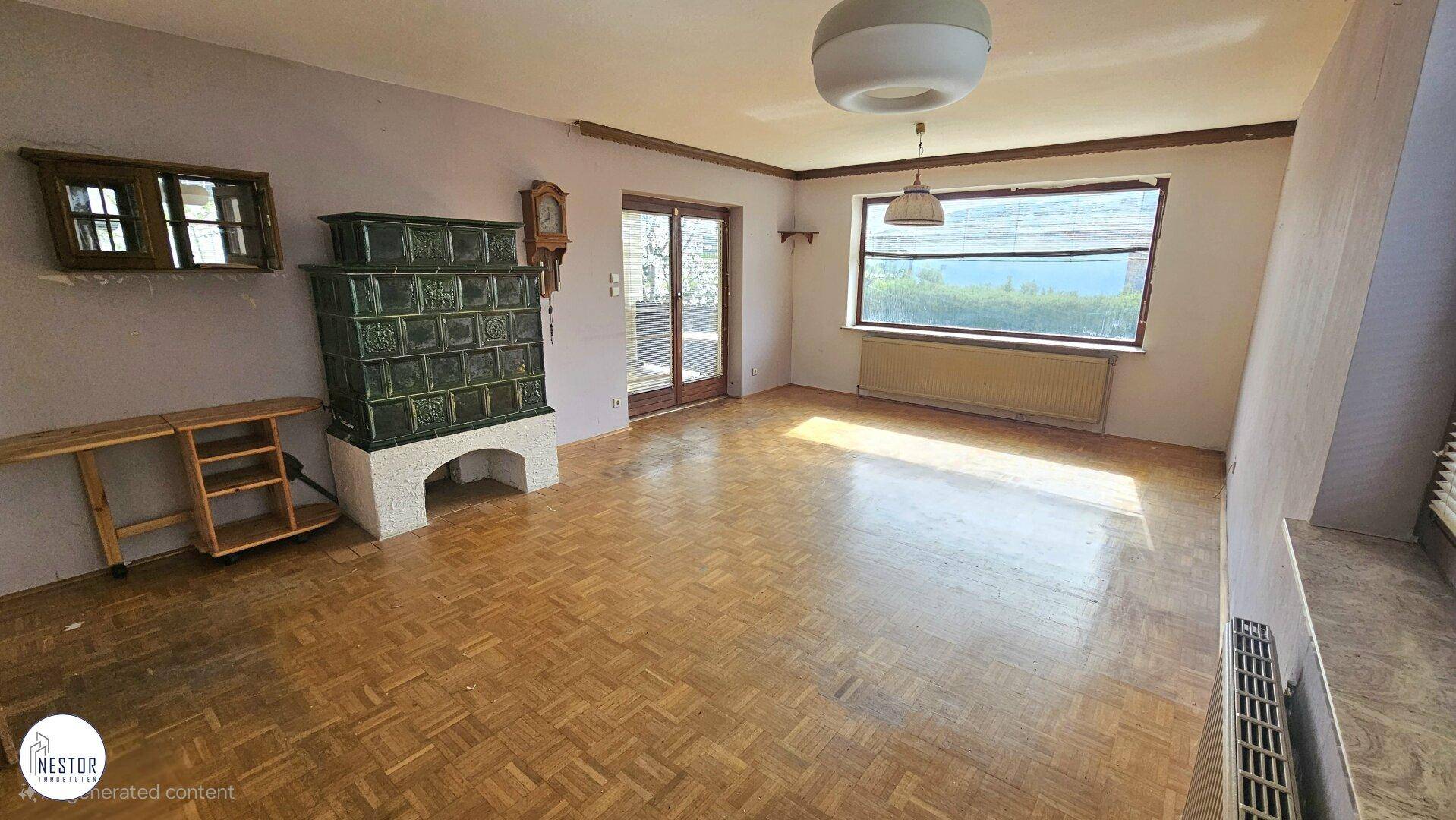 Geräumiges Wohnzimmer mit Kachelofen, Parkettboden und großen Fenstern, unmöbliert.