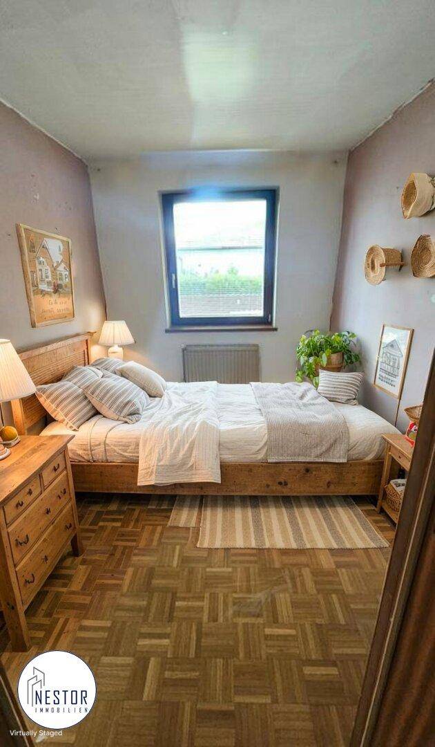 Gemütliches Schlafzimmer mit Holzbett, Parkettboden und Fenster für eine helle Atmosphäre.