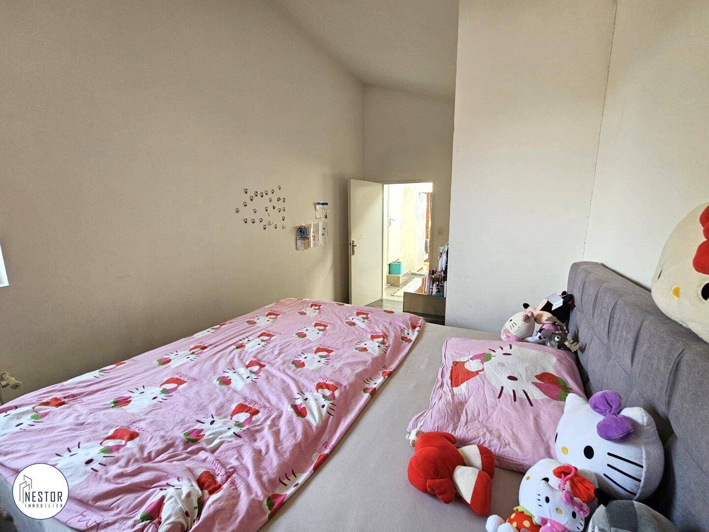 Helles Schlafzimmer mit Einzelbett, schrägen Wänden und verspielter Dekoration, ideal für Kinder.