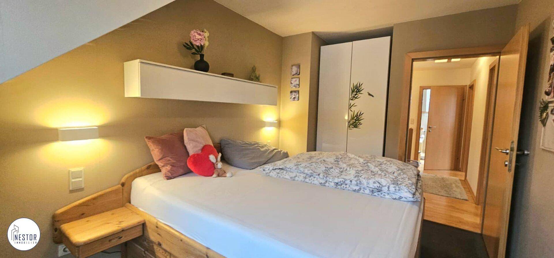 Schlafzimmer im Dachgeschoss mit schräger Decke und integriertem Kleiderschrank.