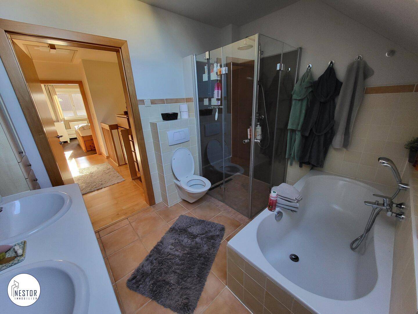 Badezimmer mit Badewanne, Duschkabine und Doppelwaschbecken.