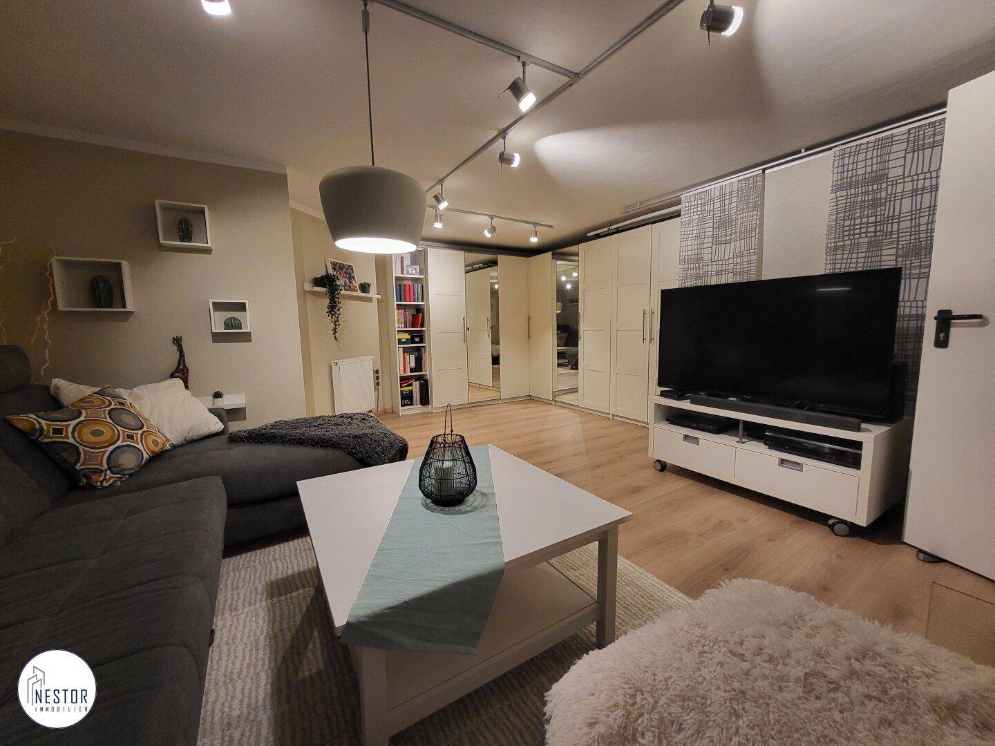 Ausgebauter Hobbyraum im Keller mit Fernseher und Stauraum.