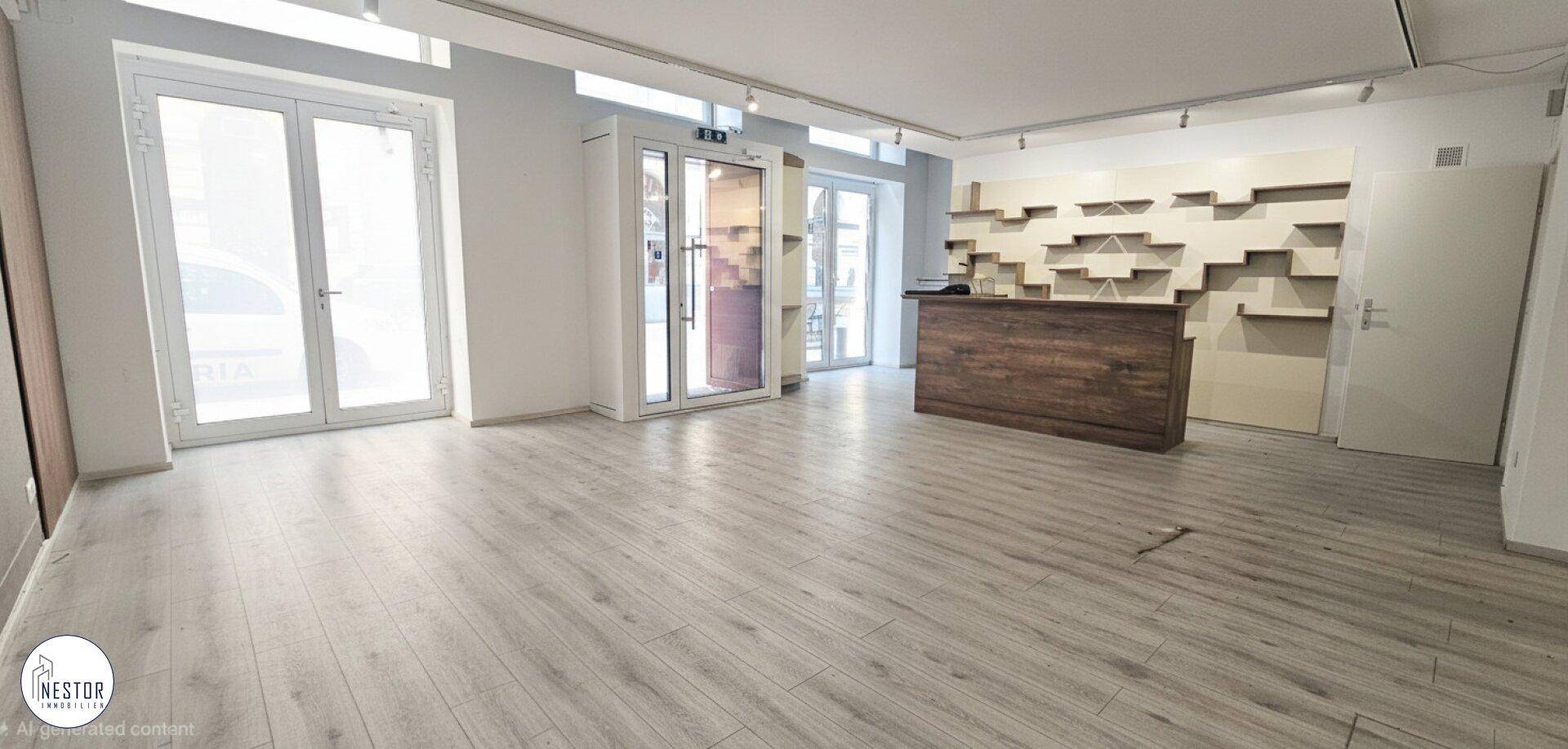 Geräumiger, heller Innenraum mit Holzboden, weiß gestrichenen Wänden und einem Empfangstresen.