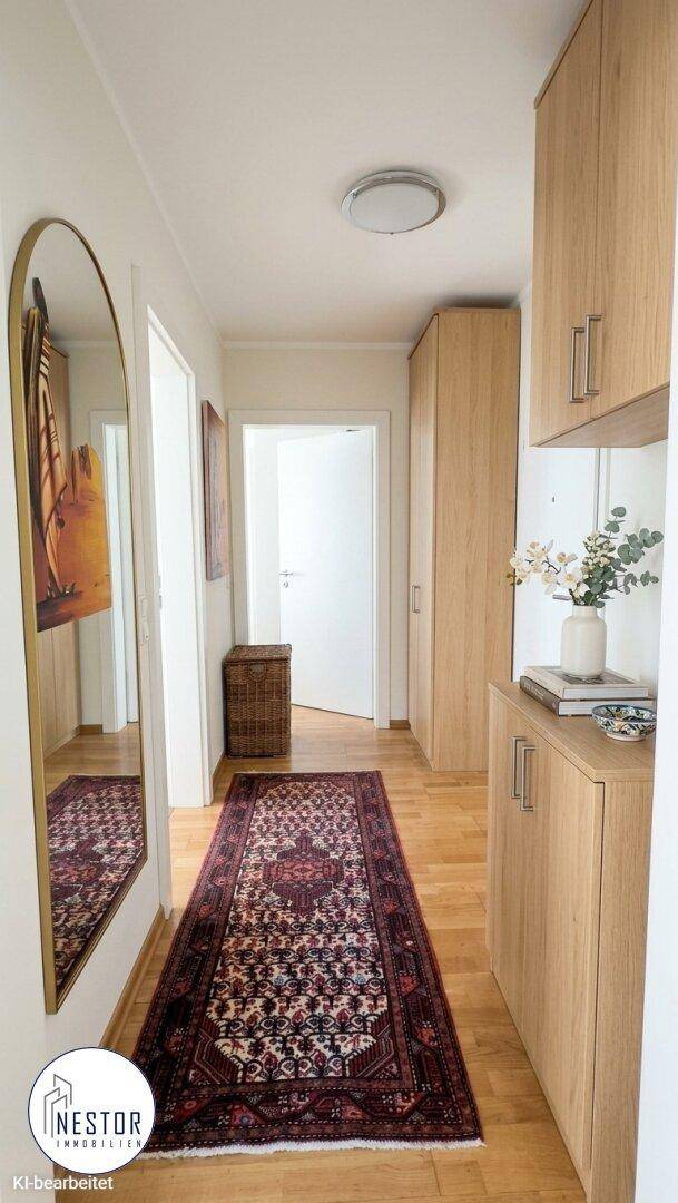 Heller Flur mit Holzboden, großem Spiegel und praktischen Einbauschränken.