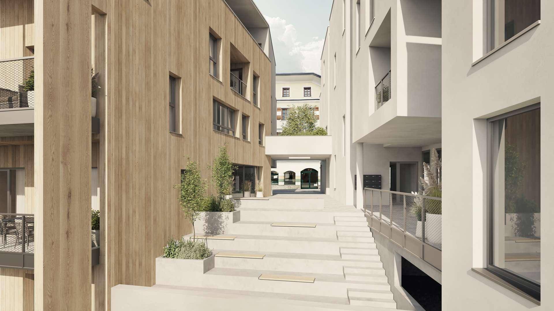 Moderner Gebäudekomplex mit Holzfassade und einem hellen Durchgangsbereich mit Treppen und Pflanzen.