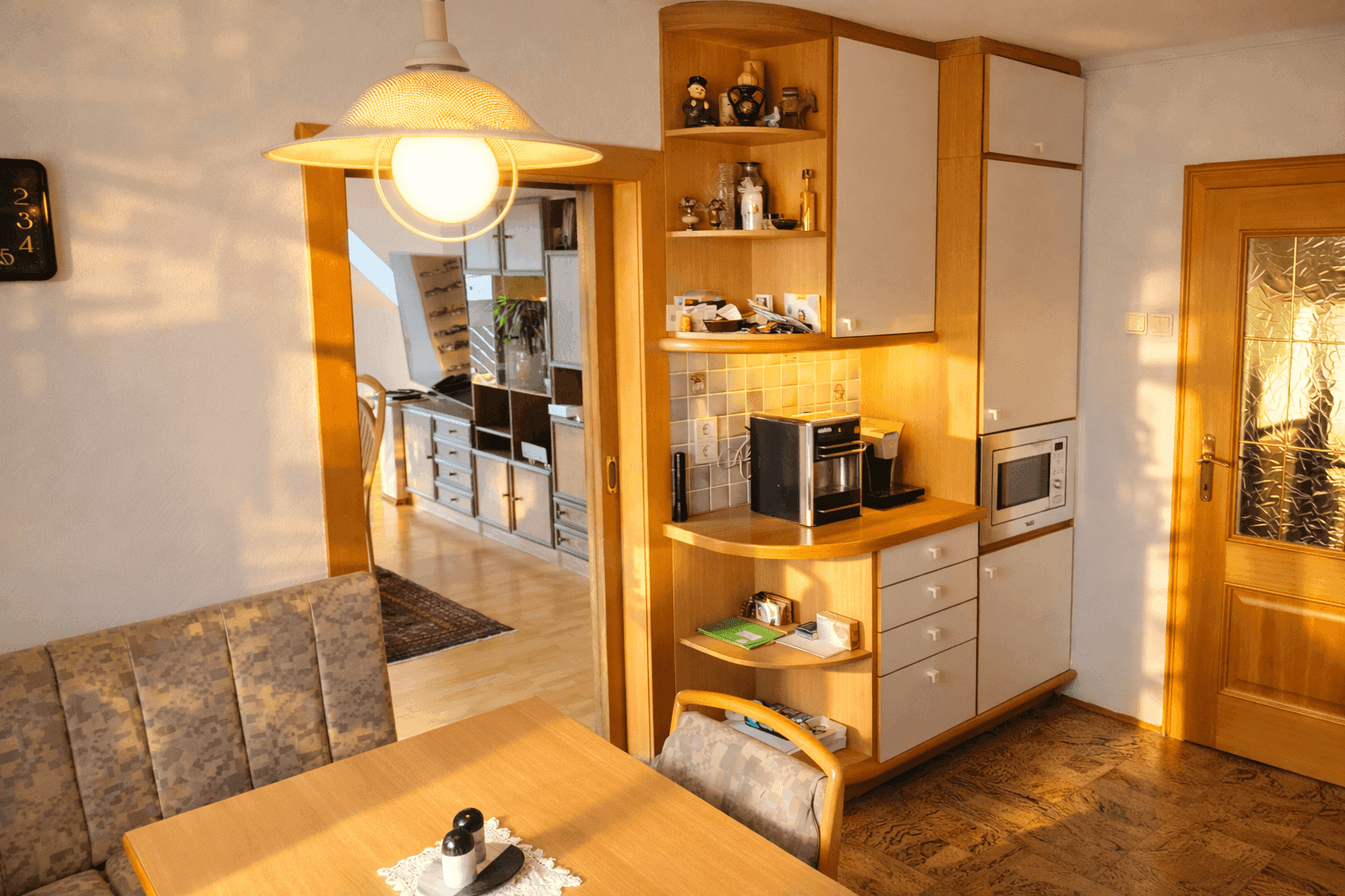Gemütliche Wohnküche mit Essbereich, Holzschränken und Blick in den angrenzenden Wohnbereich.