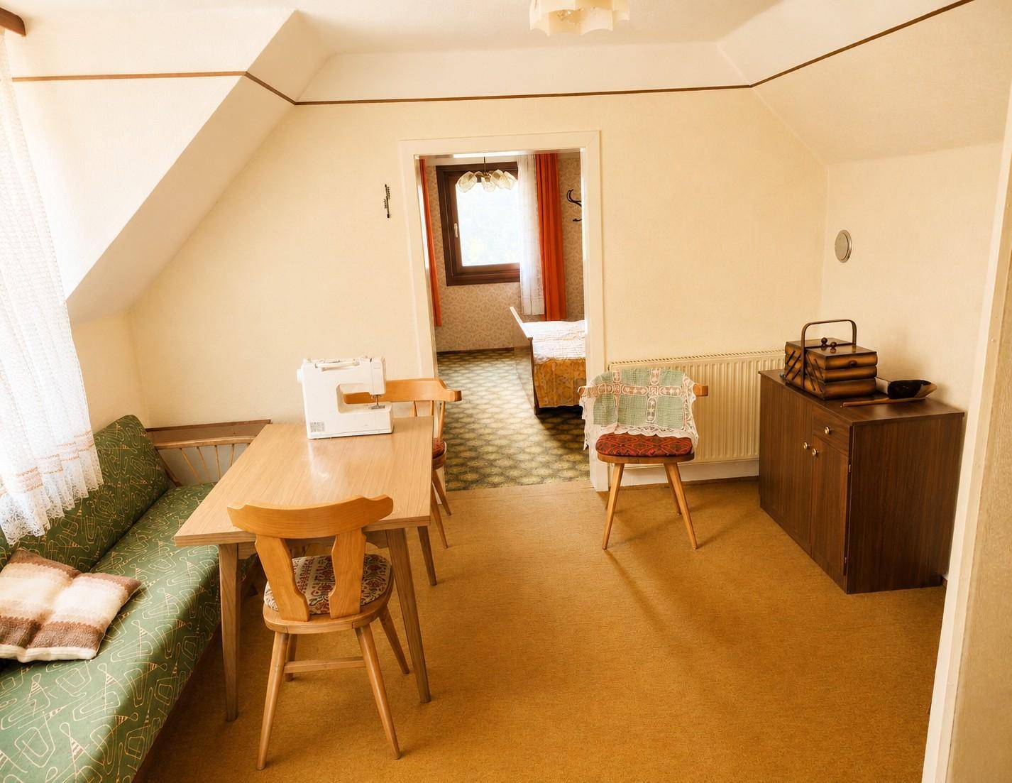 Gemütlicher Wohnbereich mit Esstisch, Sofa und Zugang zu einem weiteren Zimmer.