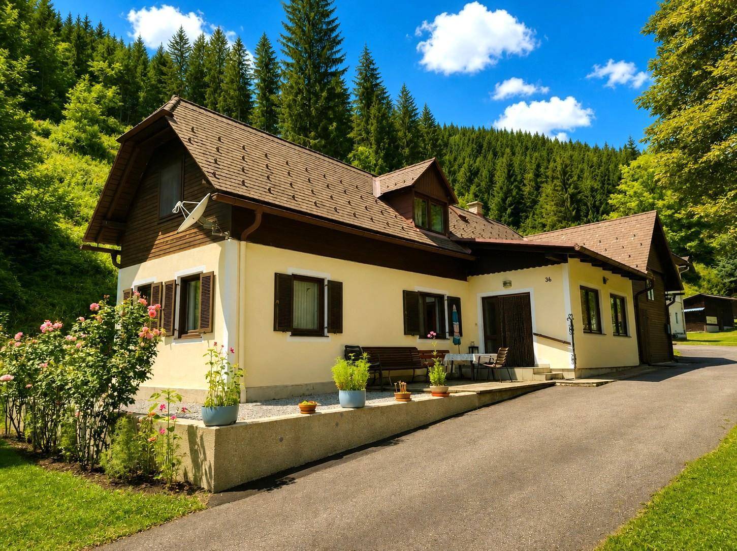 Vorderansicht des Hauses mit kleiner Terrasse, Topfpflanzen und gepflegtem Vorgarten.