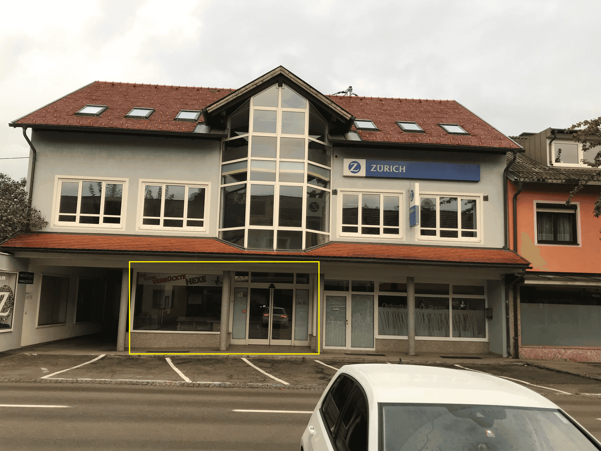 Gebäudeansicht mit hervorgehobenem Geschäftsraum im Erdgeschoss und moderner Architektur.