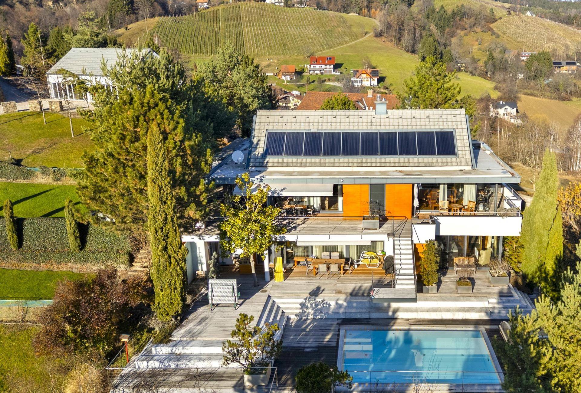 Weitläufiges Anwesen mit modernem Haus, Pool und Blick auf umliegende Weinberge.