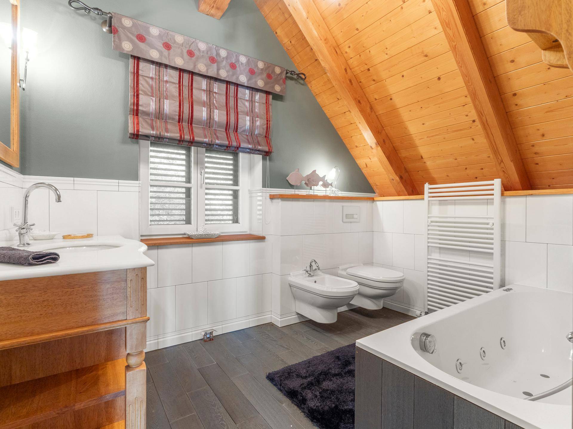 Geräumiges Badezimmer im Dachgeschoss mit Whirlpool, Bidet und beheiztem Handtuchhalter.