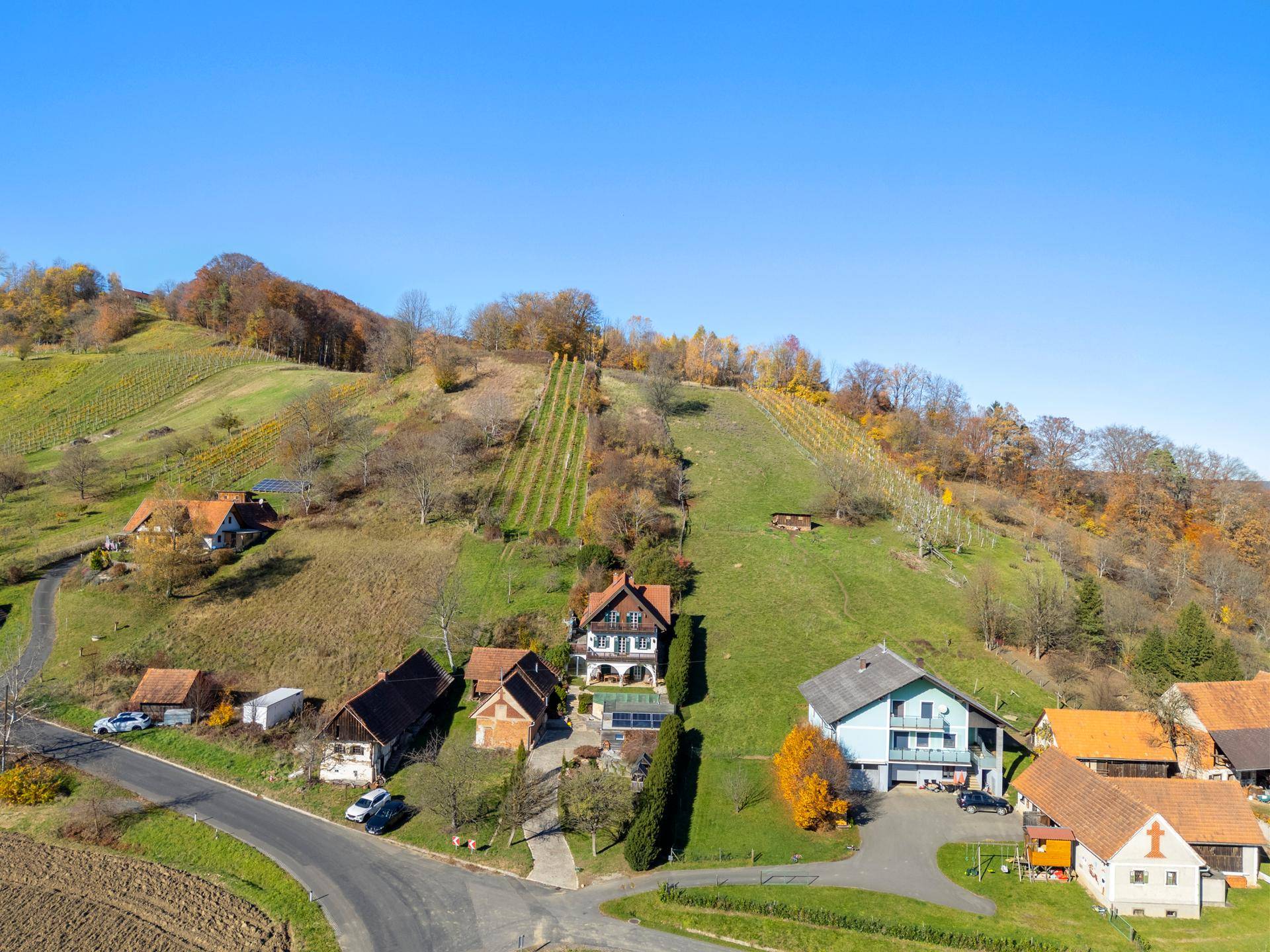 Weitläufige Ansicht des Anwesens eingebettet in die malerische Hügellandschaft mit Weinbergen.